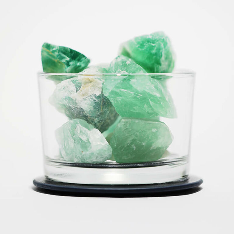 green crystal stone with glass cup